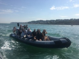 Group of passengers aboard a rib at sea. Rocket rib charters