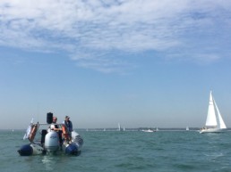Stern shot of rocket rib charters with sailing boats in the background